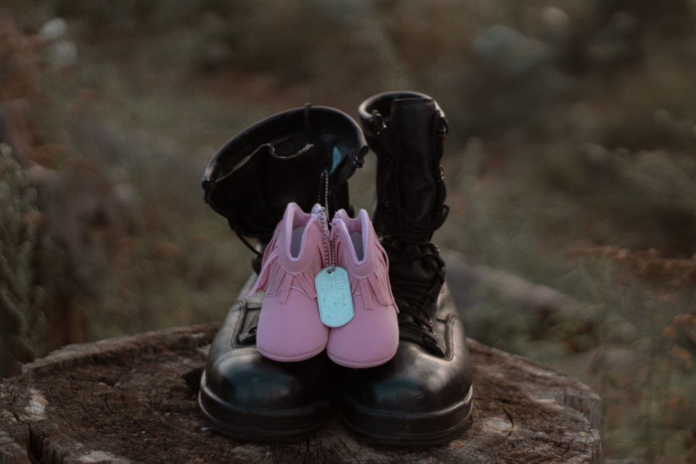 Pink and black shoes arranged artistically on natural surface.