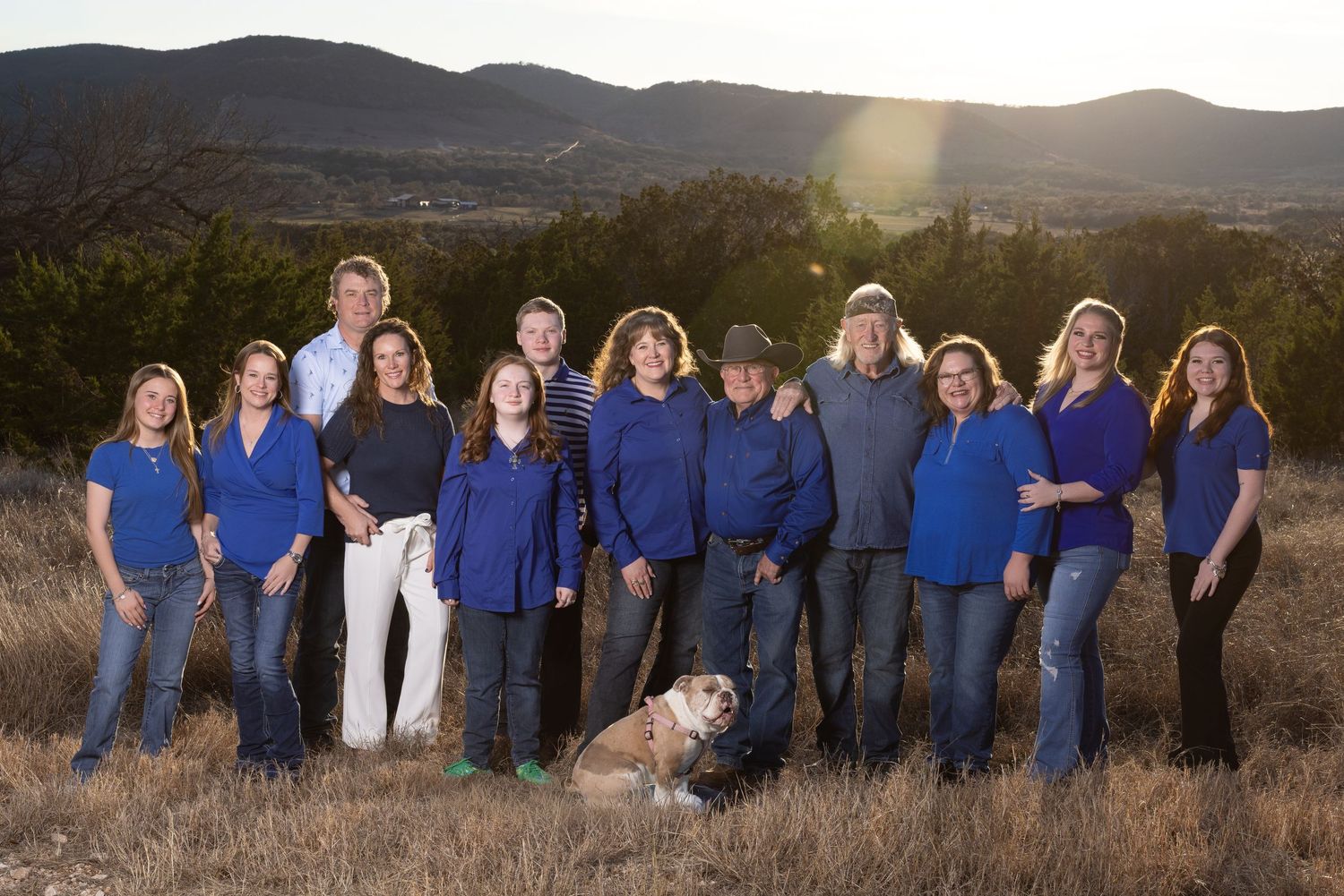 A group sitting together on outdoor stone steps in coordinating casual outfits of burgundy and blue.