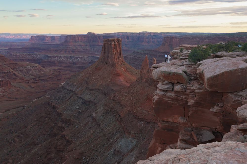 Panoramic view of towering red rock formations and deep canyons in Dead Horse Point State Park during sunset.