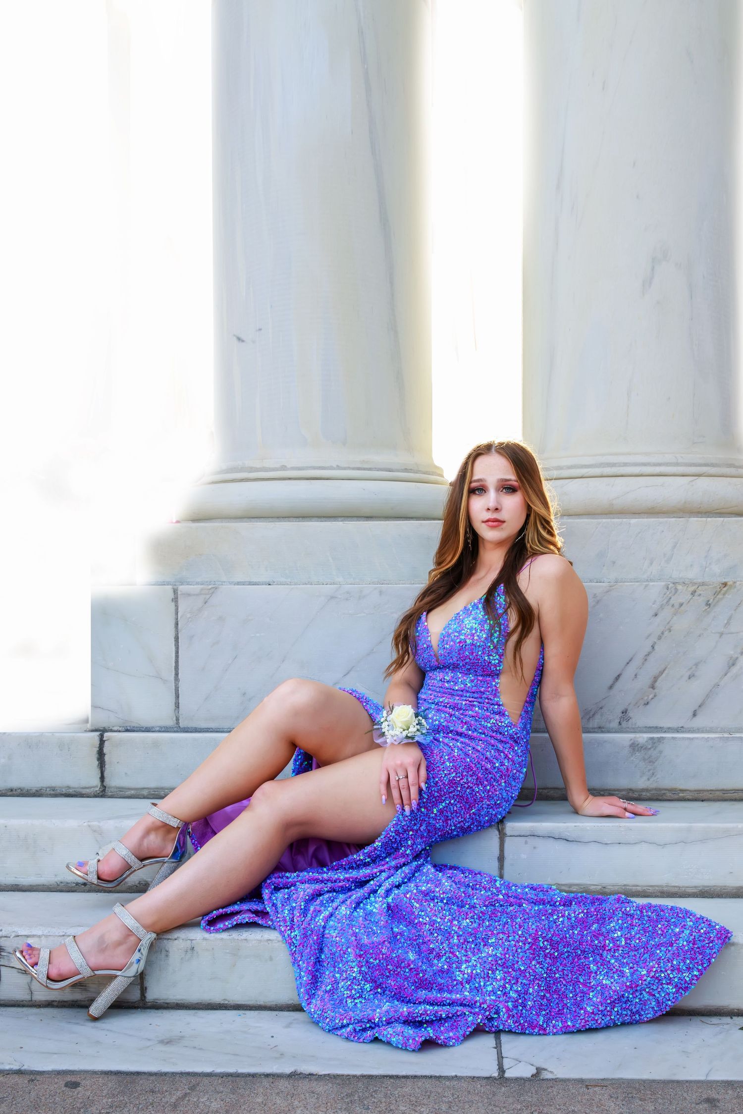 Sparkling purple sequin dress photographed against white marble architecture.