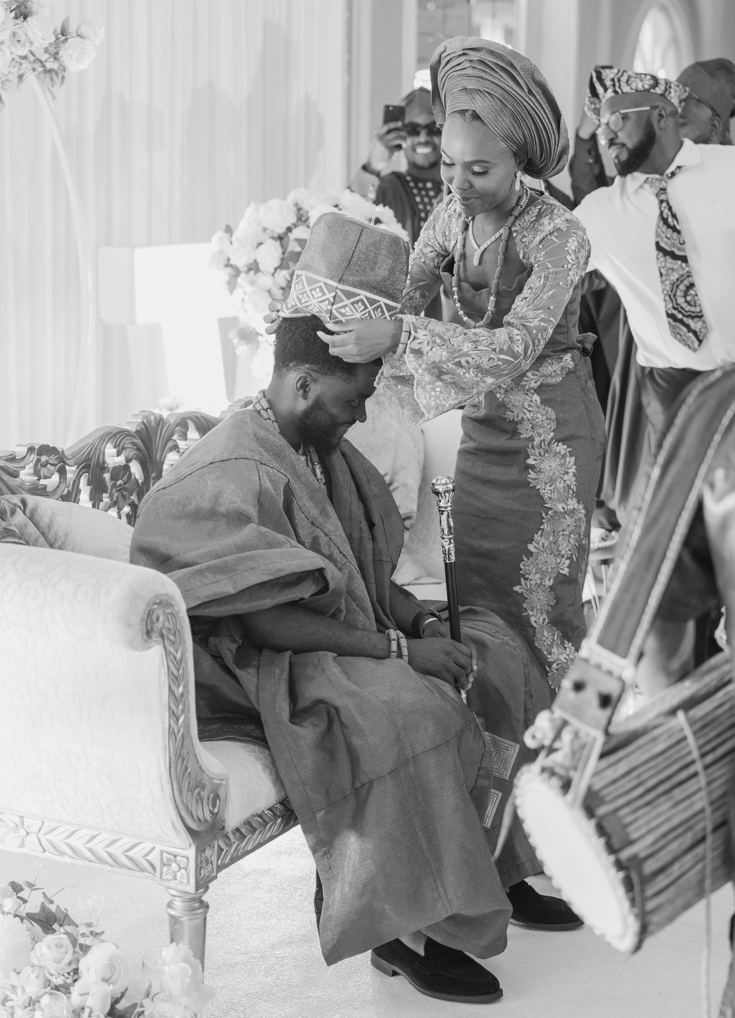 bride putting on hat on groom head in traditional setting
