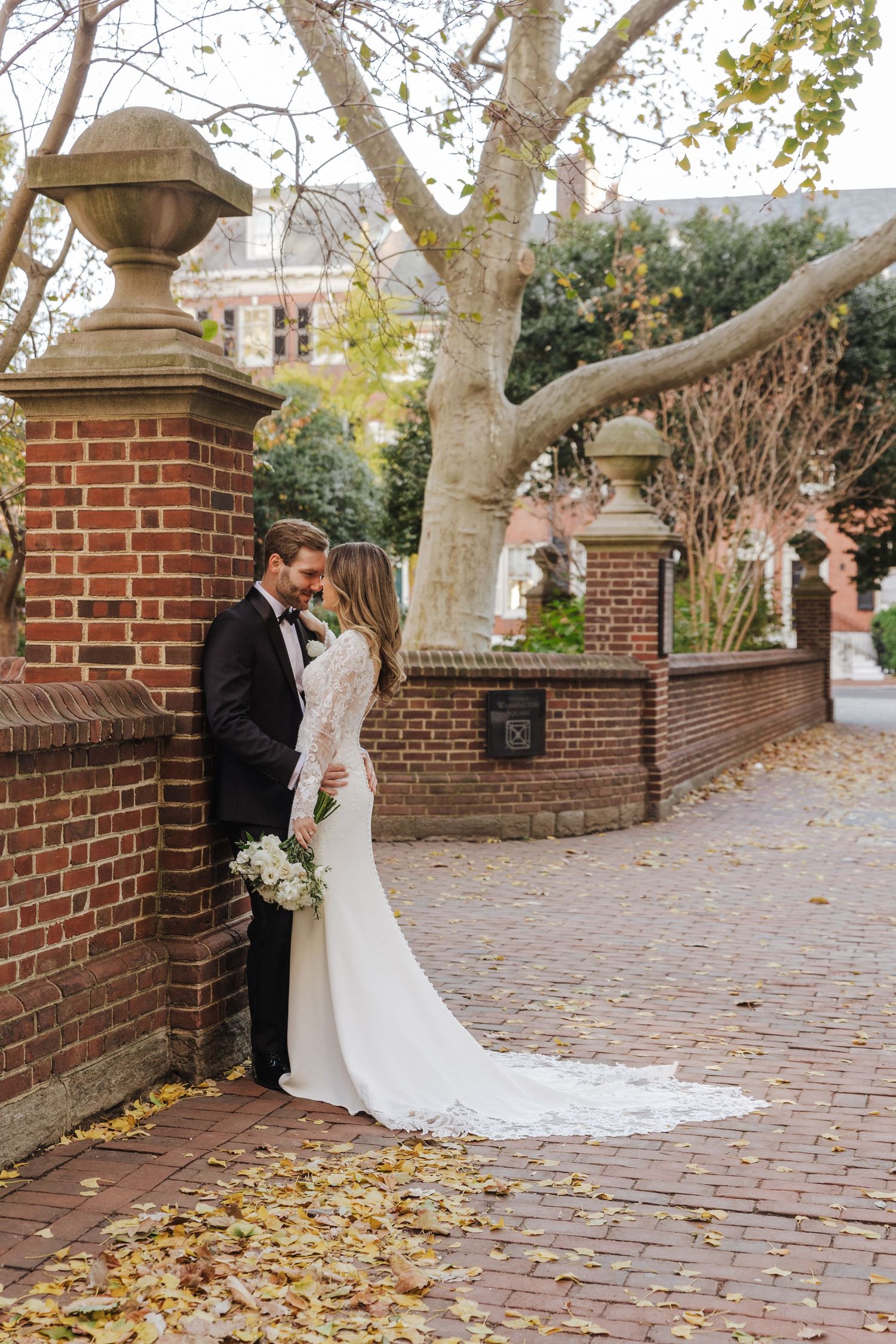 A romantic wedding moment captured on stone stairs with flowing white dress and veil caught in a gentle breeze.