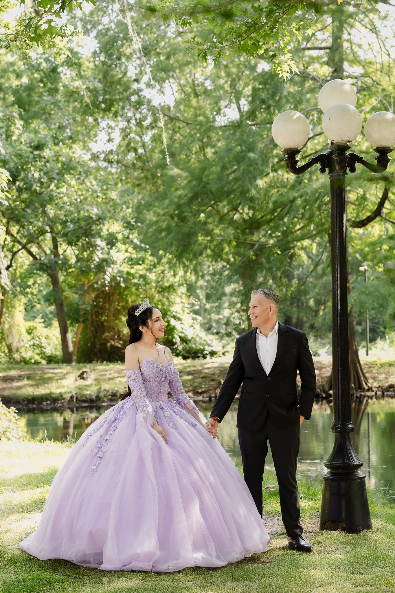 Lavender princess ball gown photographed in a scenic park setting with vintage lampposts.