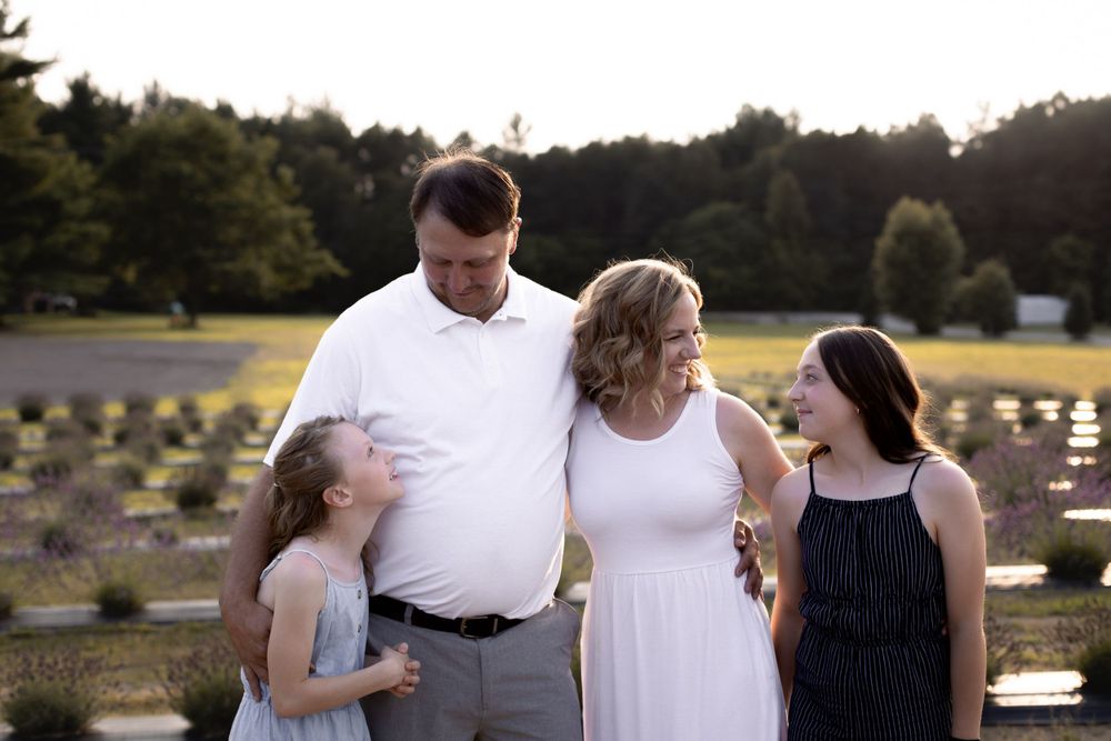 Joyful family portrait with natural expressions in a lavender field setting.