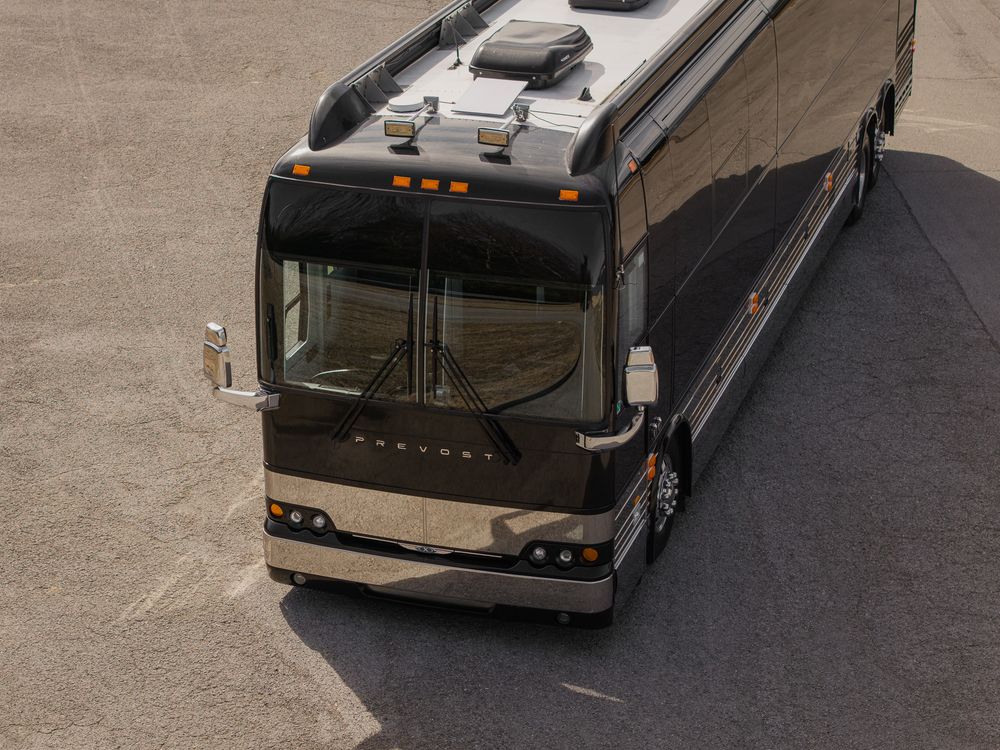 Luxury brown and tan RV motorhome parked on concrete surface viewed from above at an angle.