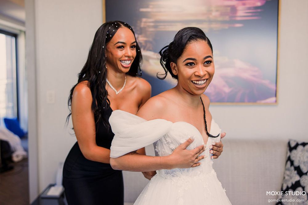 Joyful wedding party members share laughter and hugs during a celebration.