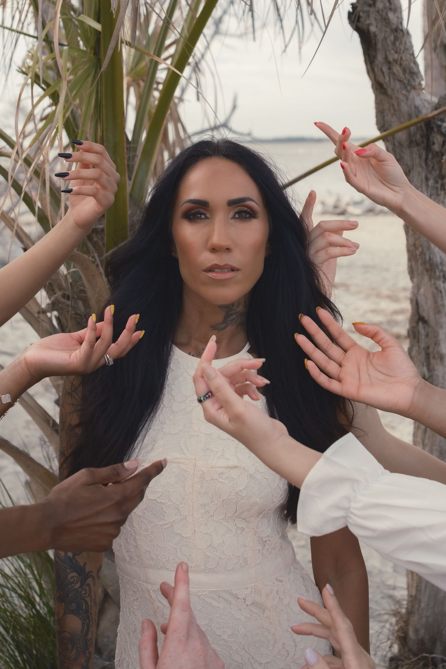 Portrait of a woman with multiple women's hands gracefully reaching toward her, symbolizing connection, support, and feminine strength