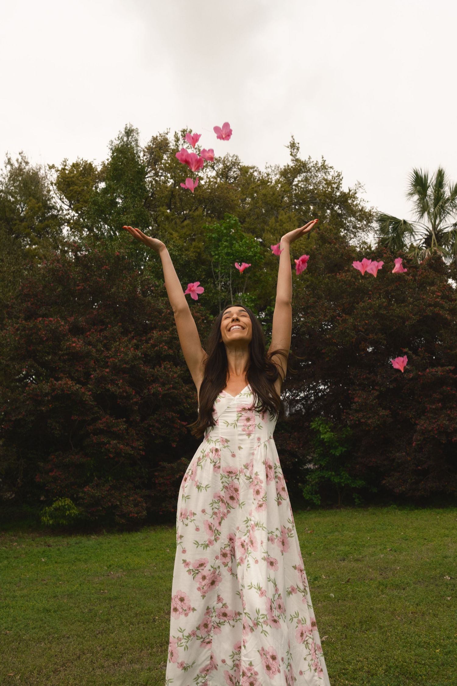 Lifestyle portrait of woman joyfully throwing azalea petals during a Charleston SC park session