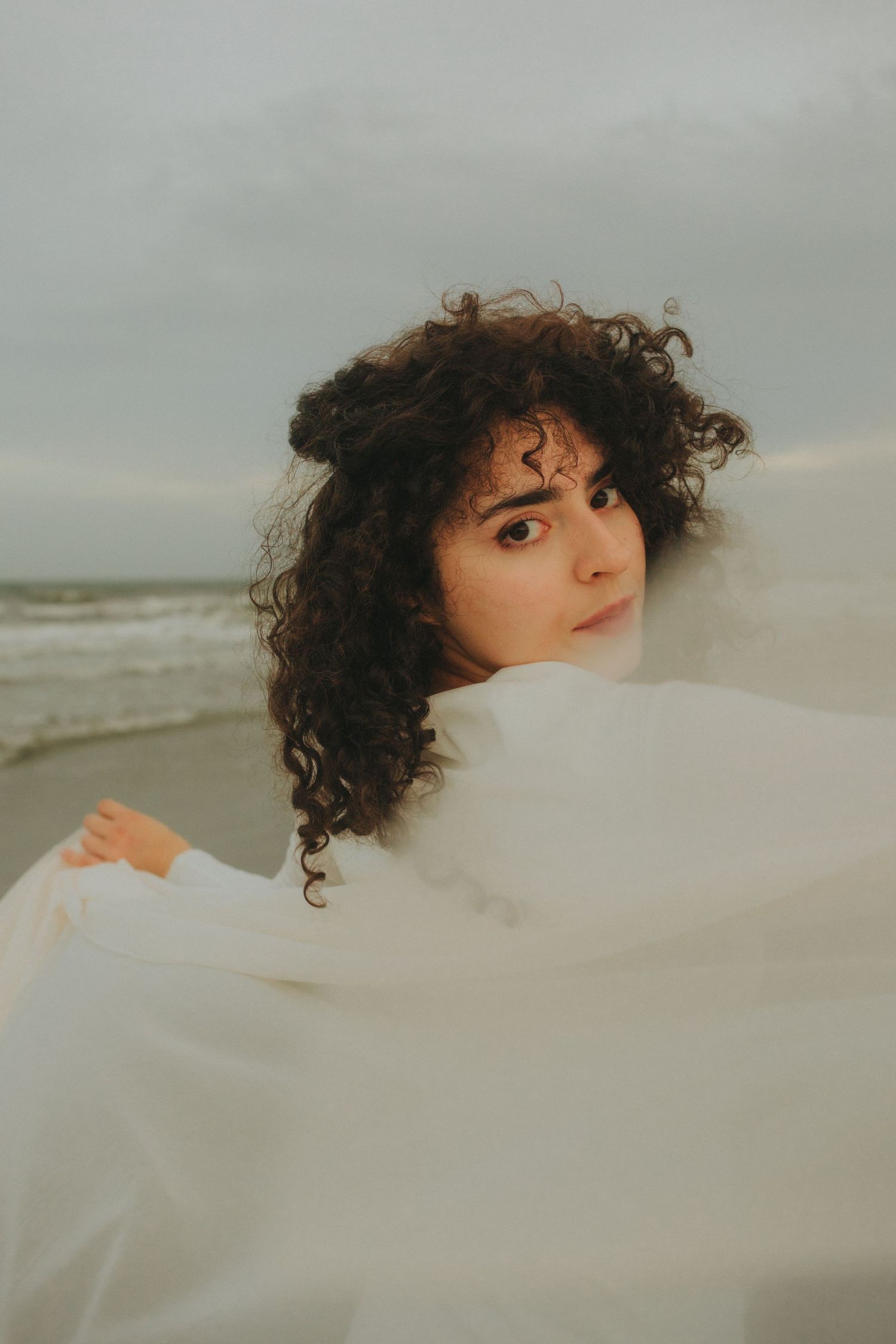 Artistic portrait of a woman by the ocean at Folly Beach in Charleston South Carolina