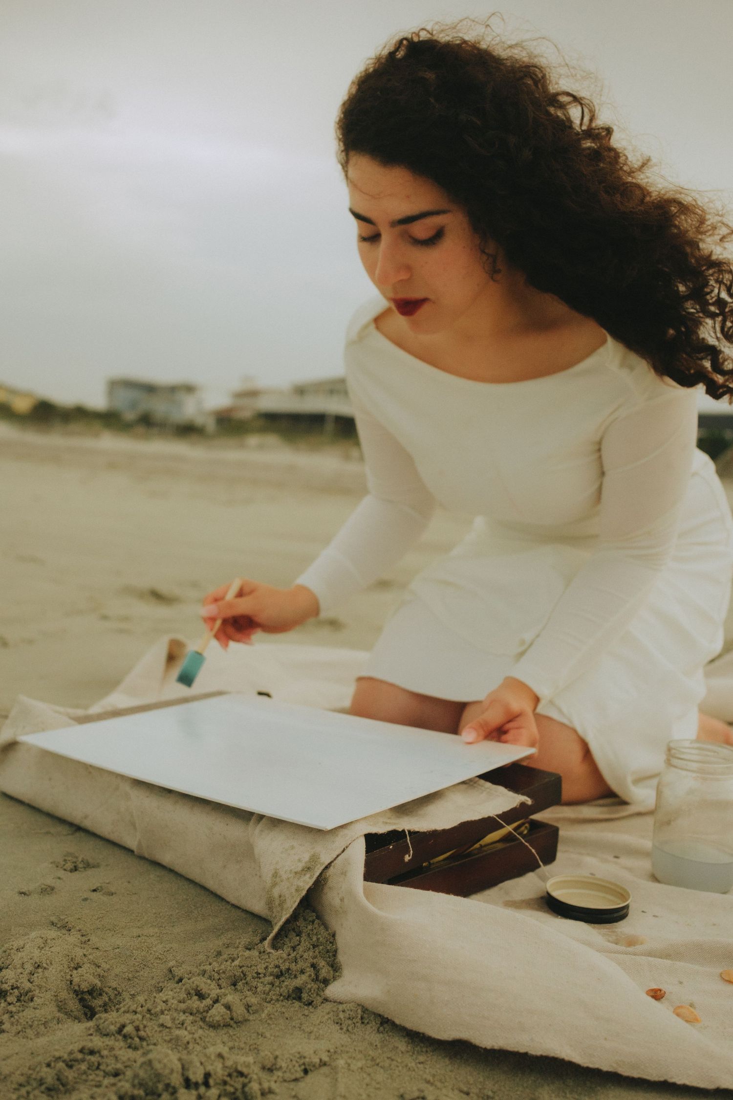 creative lifestyle photoshoot of a woman painting on the sand at Folly Beach Charleston SC