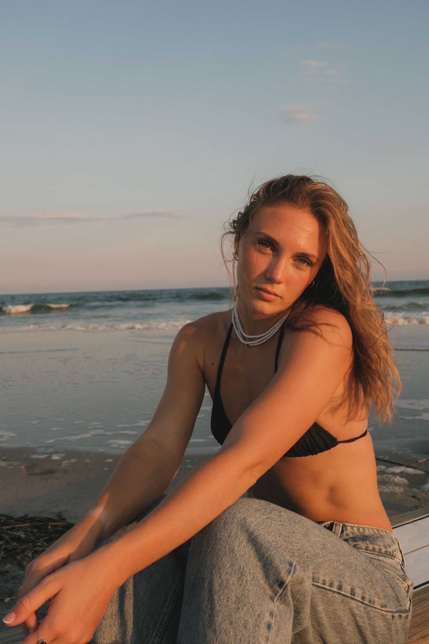 Surfer girl standing by the ocean during a Charleston Folly Beach portrait photoshoot