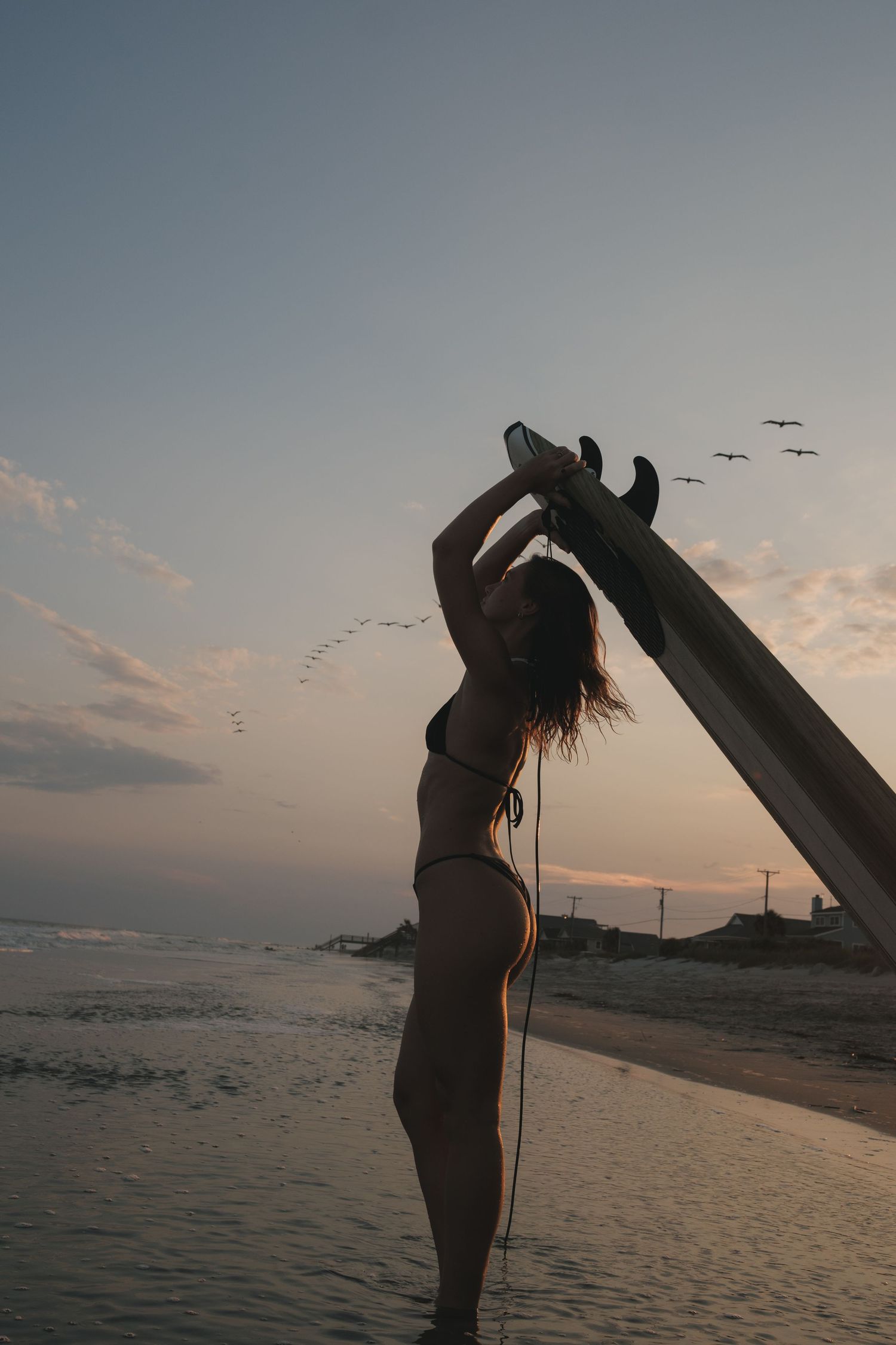 Lifestyle portrait of a surfer girl at Folly Beach in Charleston, South Carolina