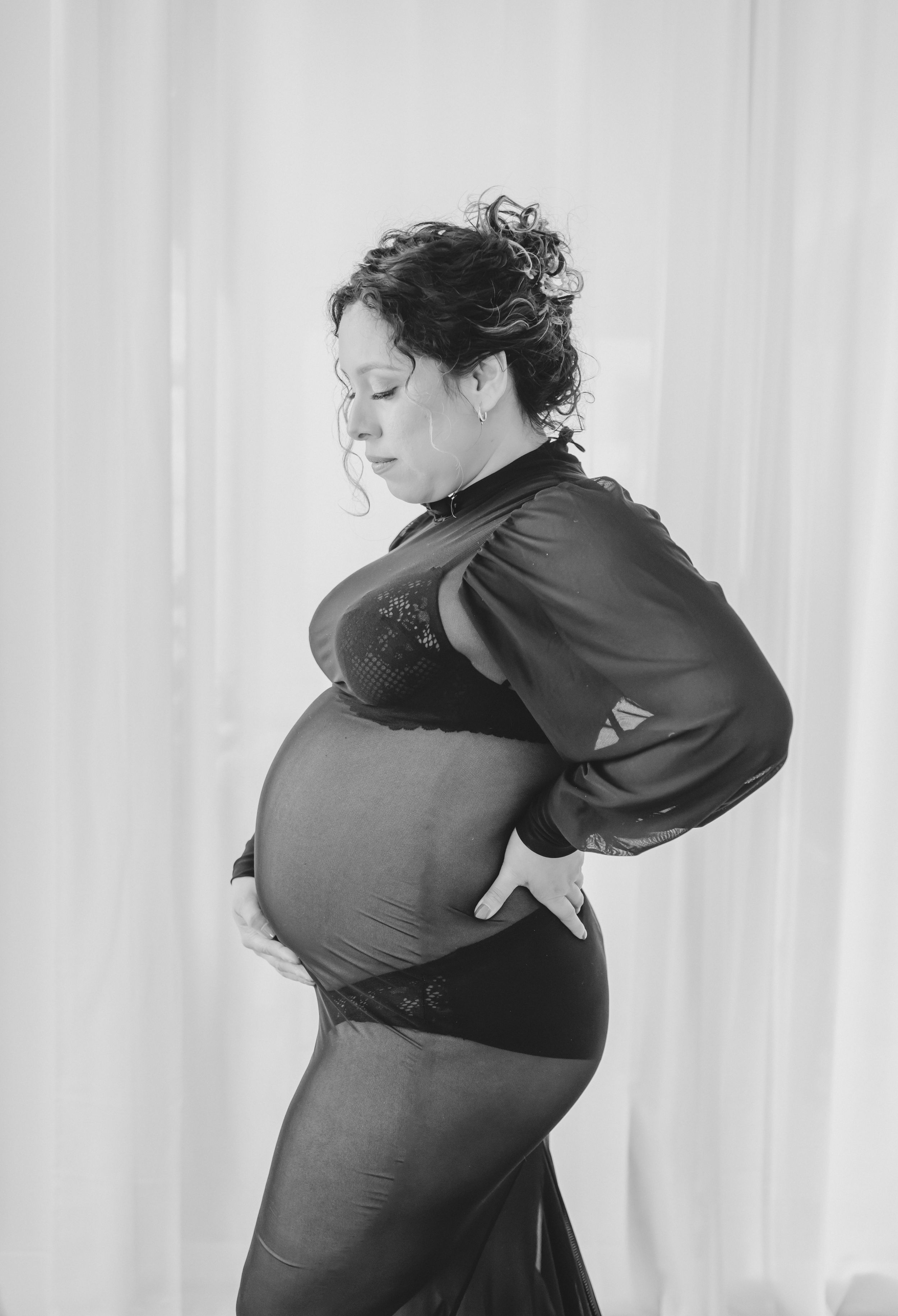 Classic black and white maternity portrait in elegant lace and flowing sleeves.