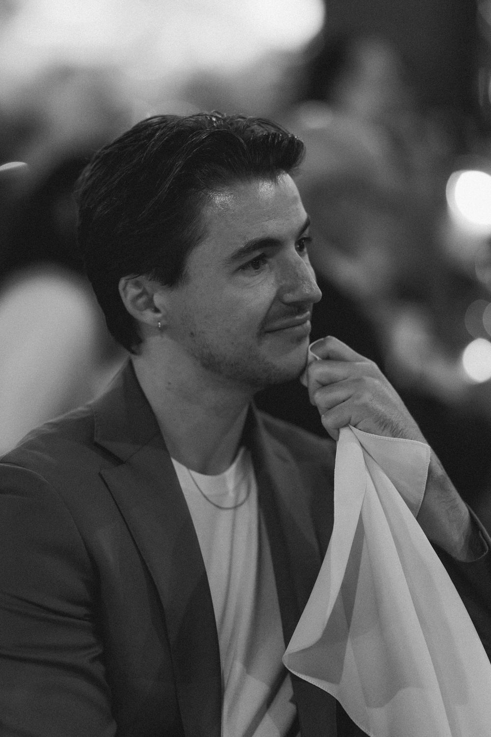 Black and white profile view of wedding guests during an emotional moment.