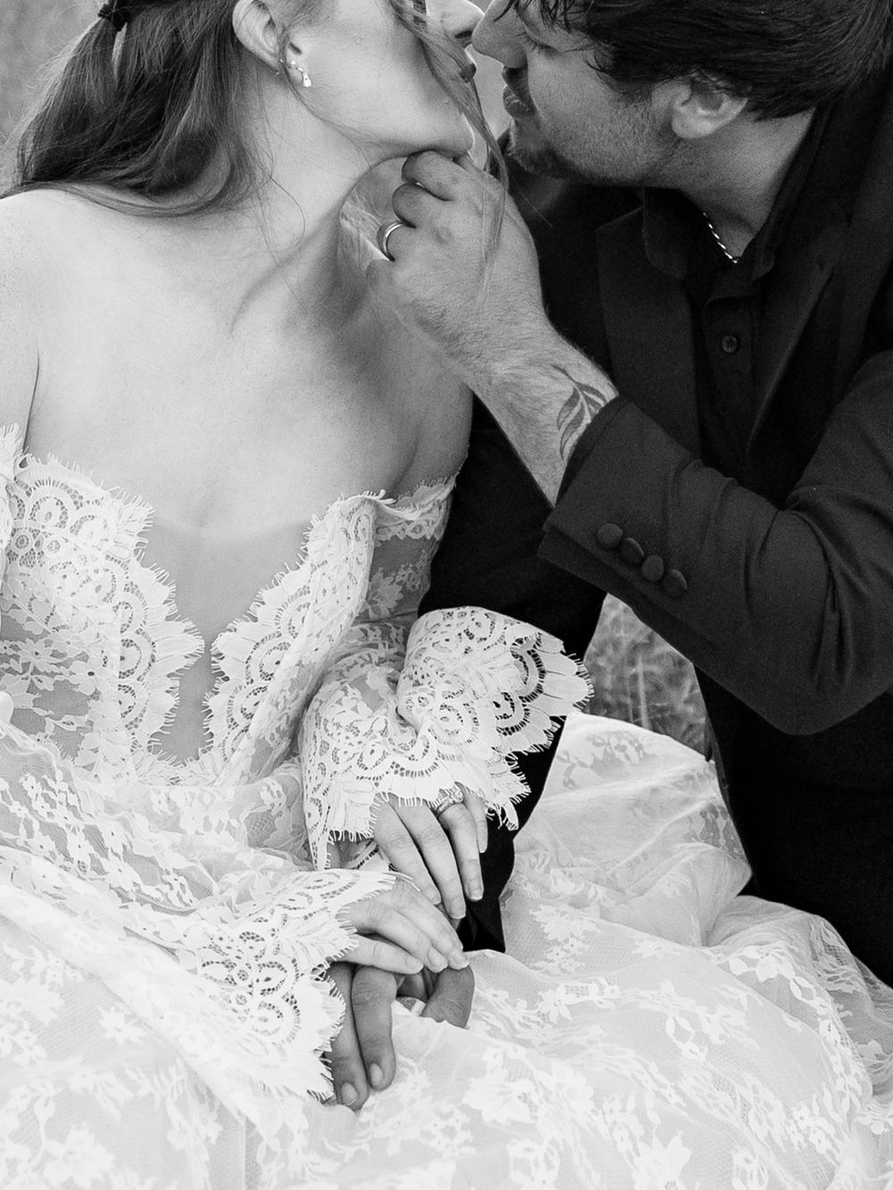 A romantic black and white wedding photo series showing tender moments between a bride in lace and her partner.