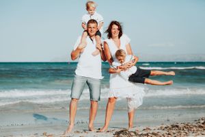 A family playing on the beach shoreline during a fun, unscripted lifestyle vacation photography session in Mallorca.