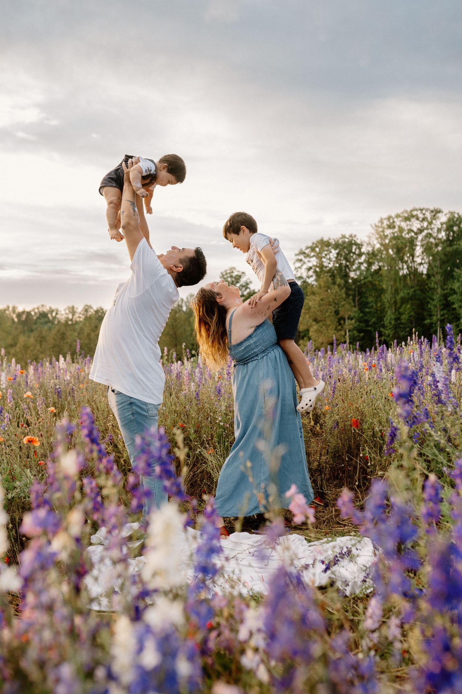 A family of four is on a picnic in a flower field