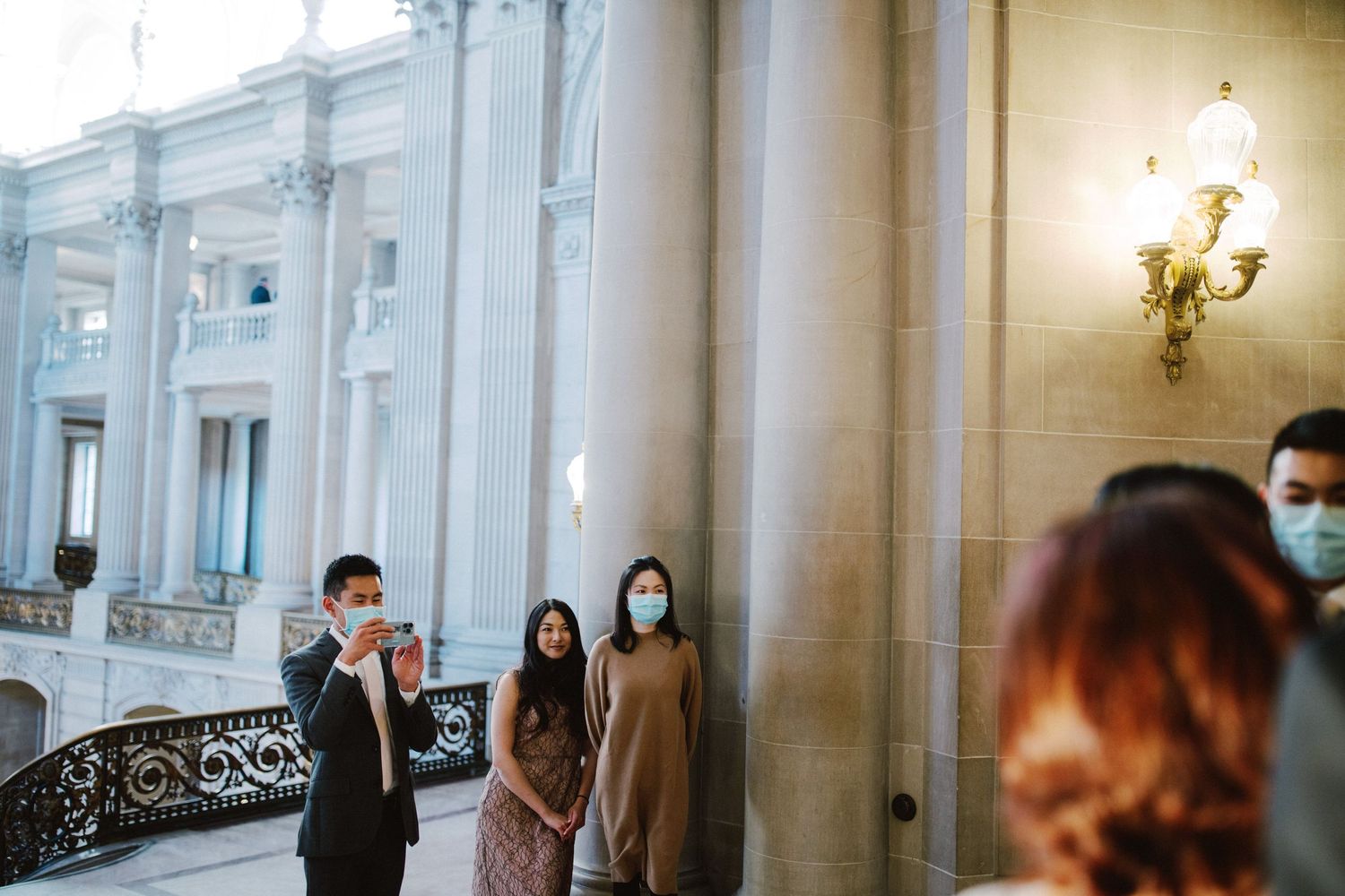 Wedding ceremony in an elegant venue with people wearing face masks during the pandemic.