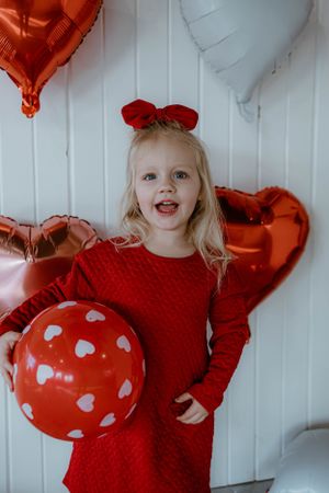 Sweet Valentine's photo featuring red dress against heart balloon backdrop.