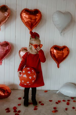 Valentine's themed photo with heart balloons, polka dot balloon and red heart glasses.