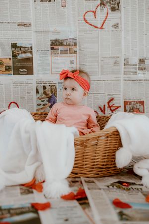 Sweet Valentine's photo setup with newspaper wall backdrop and wicker basket prop.