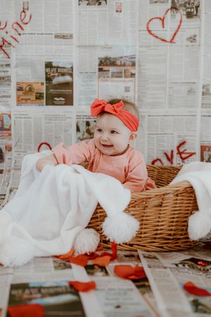 Charming Valentine's photo with newspaper backdrop and wicker basket arrangement.
