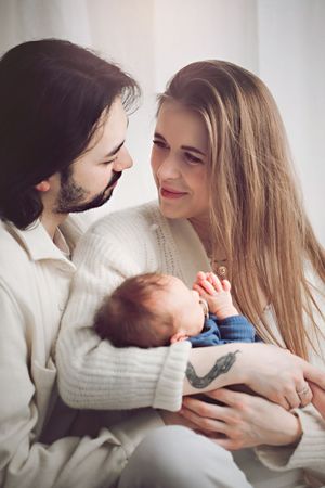 Intimate family moment as parents gaze lovingly at their newborn baby.