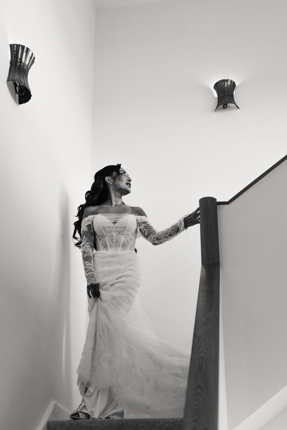 A figure in a white dress appears to be floating or falling through a minimalist white space in a dramatic sequence.