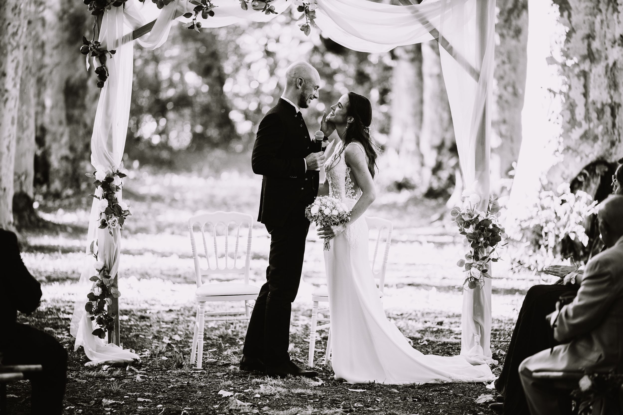 A series of black and white photos showing a couple walking together in a wooded outdoor setting.