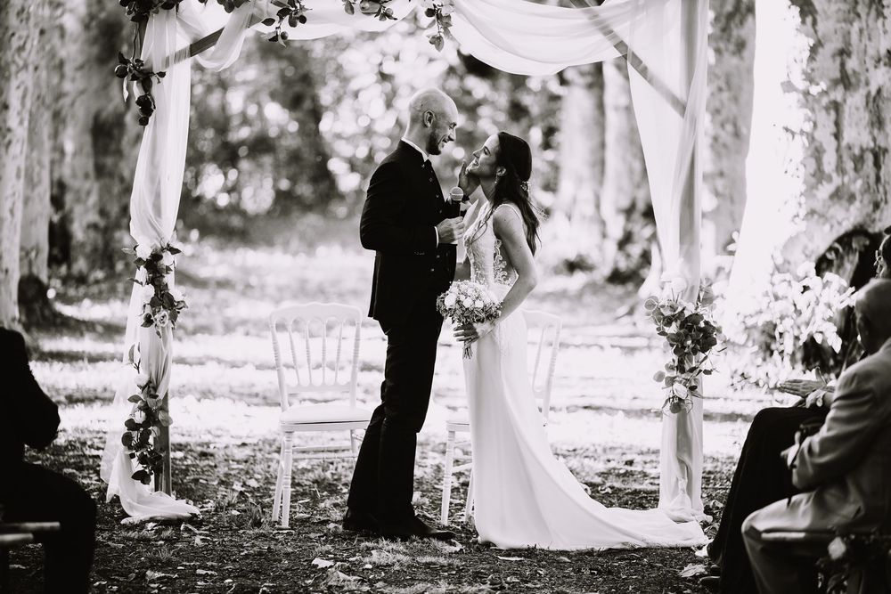 A series of black and white photos showing a couple walking together in a wooded outdoor setting.