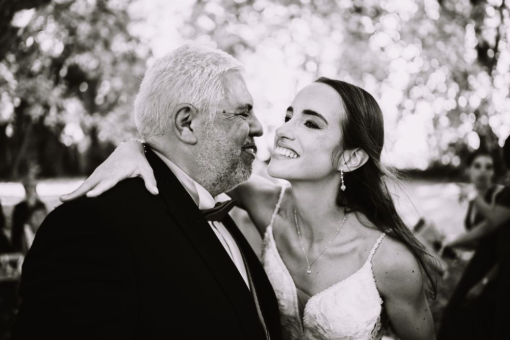 A couple shares tender moments in black and white wedding photos showing kisses and laughter.