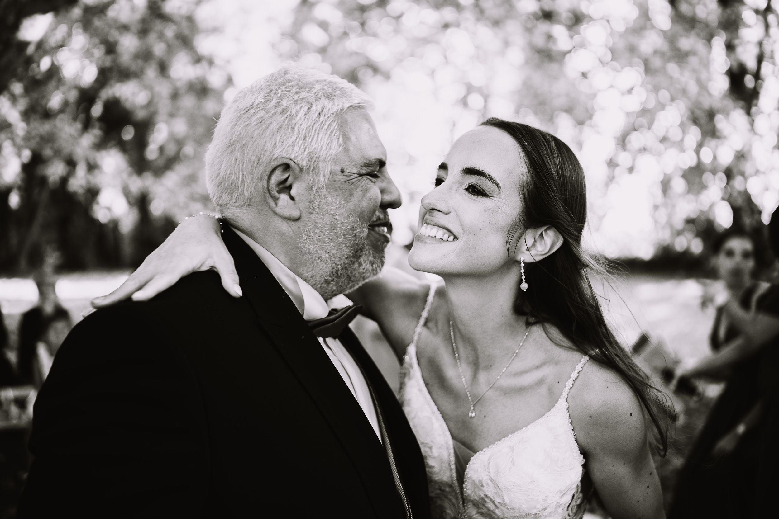 A couple shares tender moments in black and white wedding photos showing kisses and laughter.