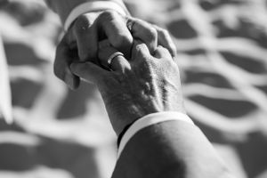 Close-up black and white photo showing hands tenderly touching.. photographe mariage lgbt Bordeaux gironde