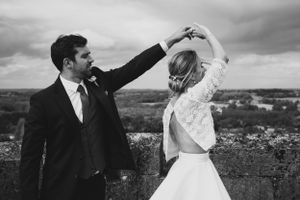 Couple dancing together on hilltop overlooking scenic landscape. photographe mariage Bordeaux gironde
