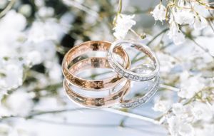 Wedding rings photographed with white flowers in soft light. photographe mariage Bordeaux gironde