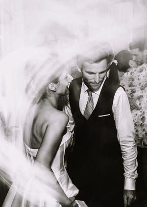 Black and white wedding photos show couple joyfully laughing and dancing together in romantic sequence.