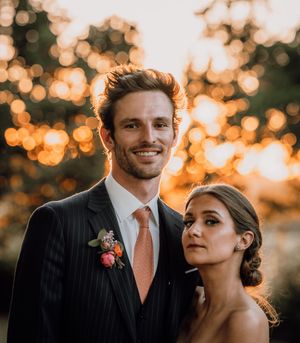 Newlyweds share intimate moments at sunset with golden bokeh lights creating dreamy atmosphere.