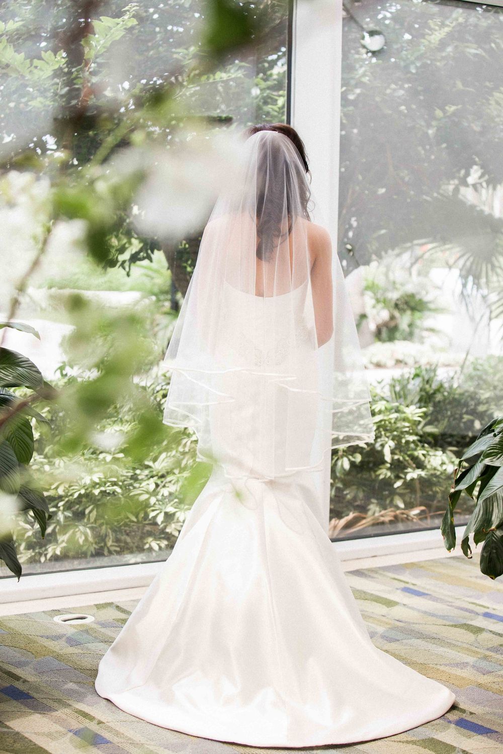A series of romantic bridal photos showing a white wedding dress with a flowing veil in a sunlit garden setting.
