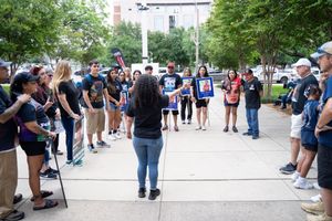 Group of people gathered for outdoor community meeting or rally.
