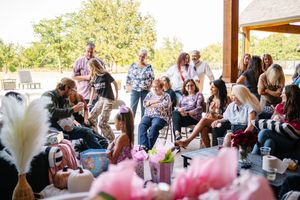 A baby shower celebration with guests gathered under a covered outdoor patio area.