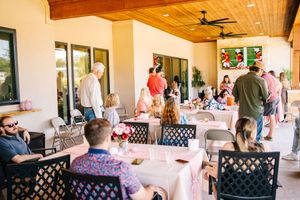 Interior view of a venue with wooden ceiling and guests seated along tables.