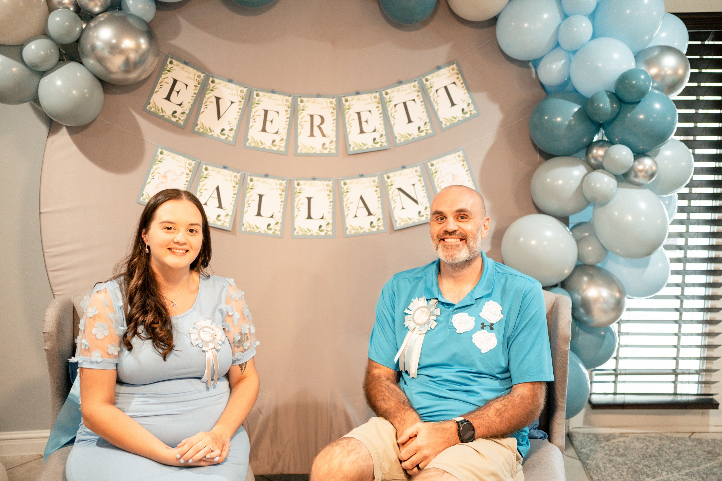 A baby shower celebration with blue and white balloon decorations and 'Everett Atlas' banner.