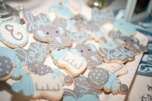 Decorated sugar cookies with baby elephants and blue designs for a baby shower.