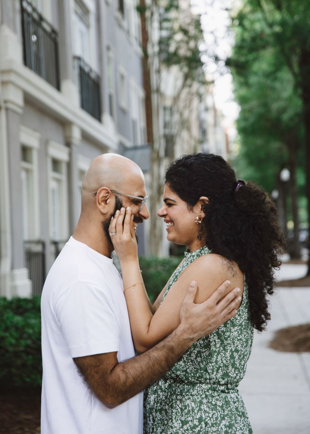 Couple shares an intimate emotional moment on a tree-lined city street.