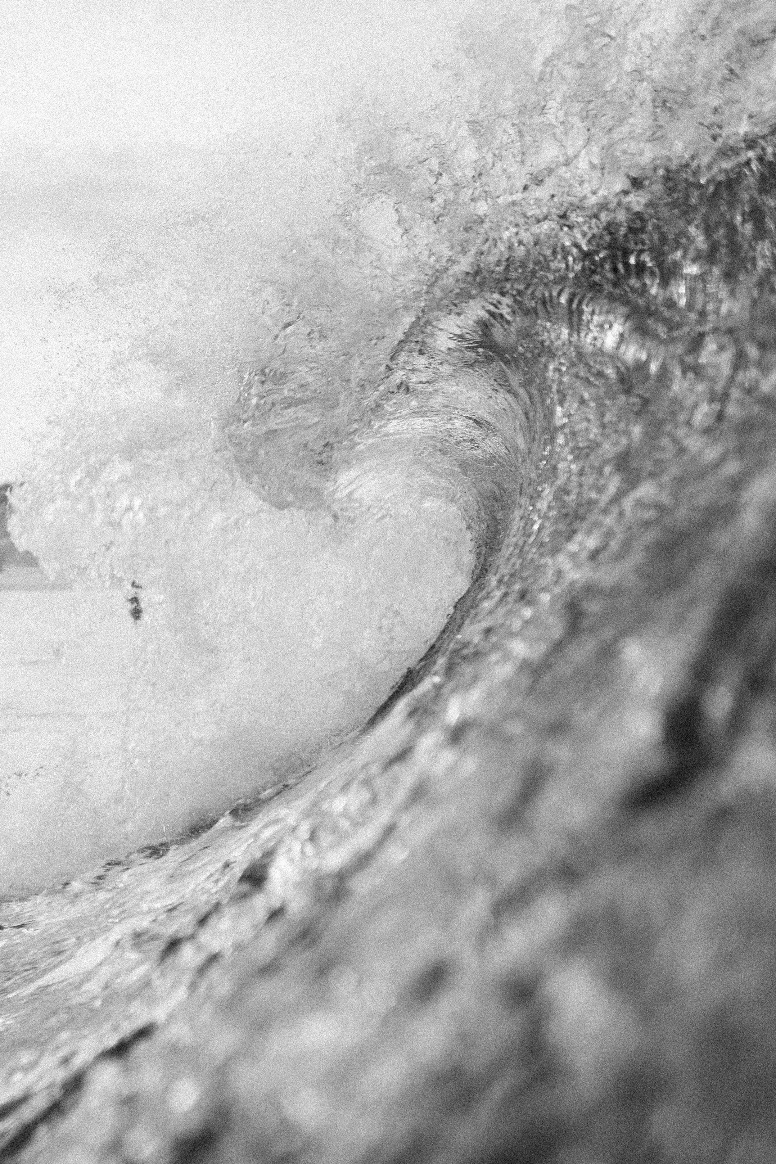 Massive wave curls in black and white photography creating a perfect barrel.