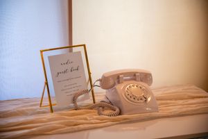 Vintage rotary telephone and framed invitation create a nostalgic wedding vignette.