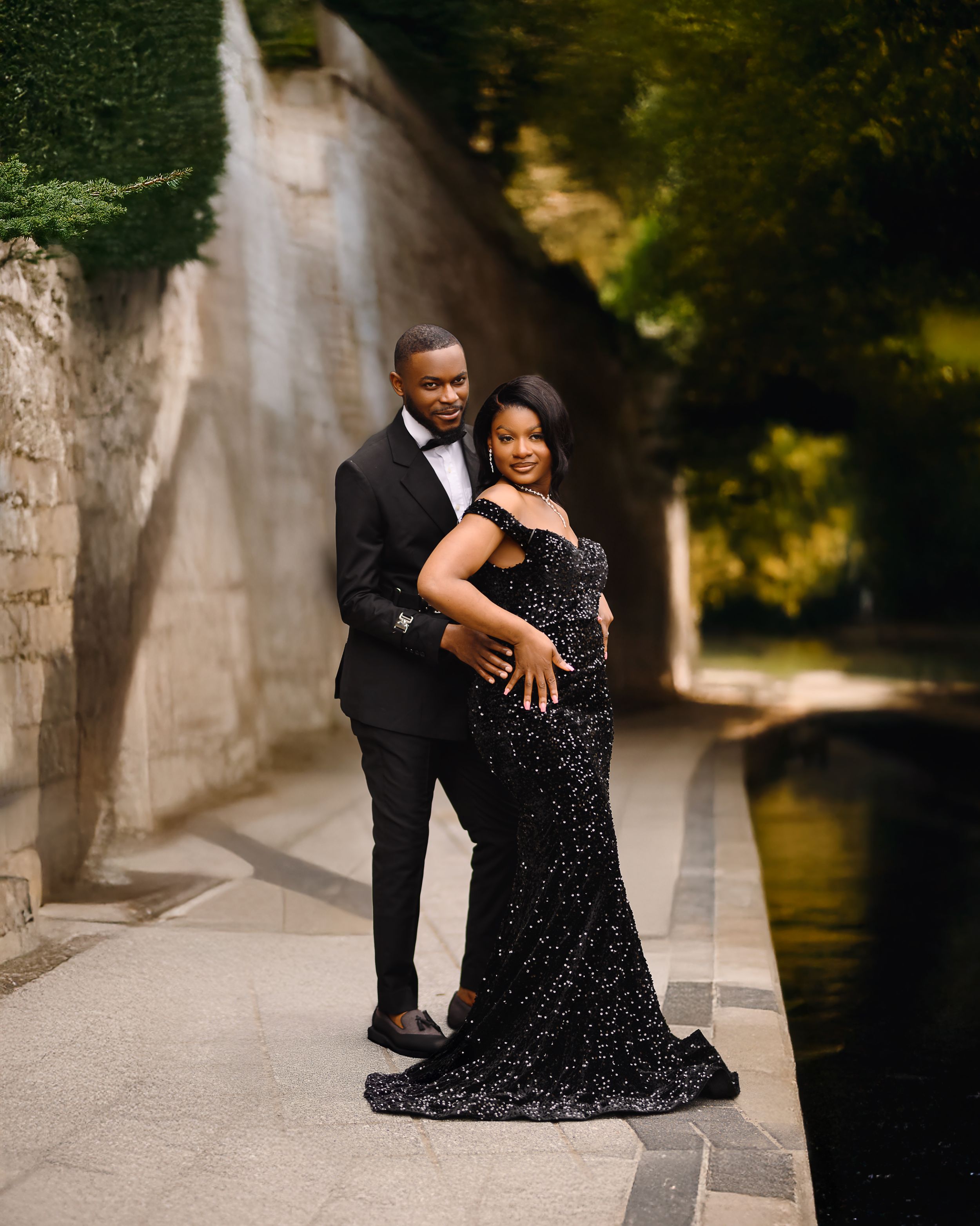 Roma couple in formal attire sharing an intimate moment on stone steps during a romantic outdoor photoshoot.