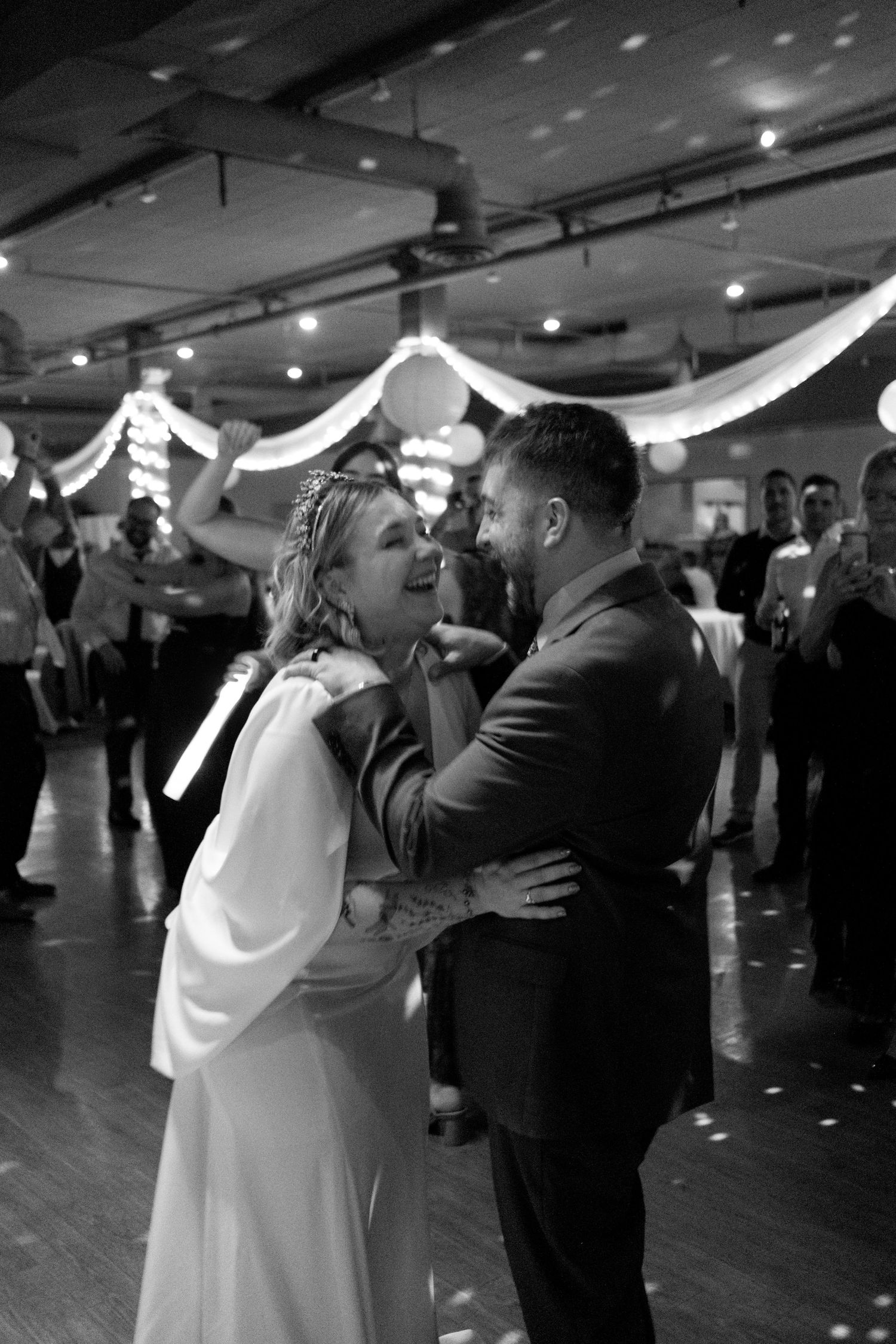 Newlyweds walking down the aisle at outdoor garden wedding while guests celebrate.