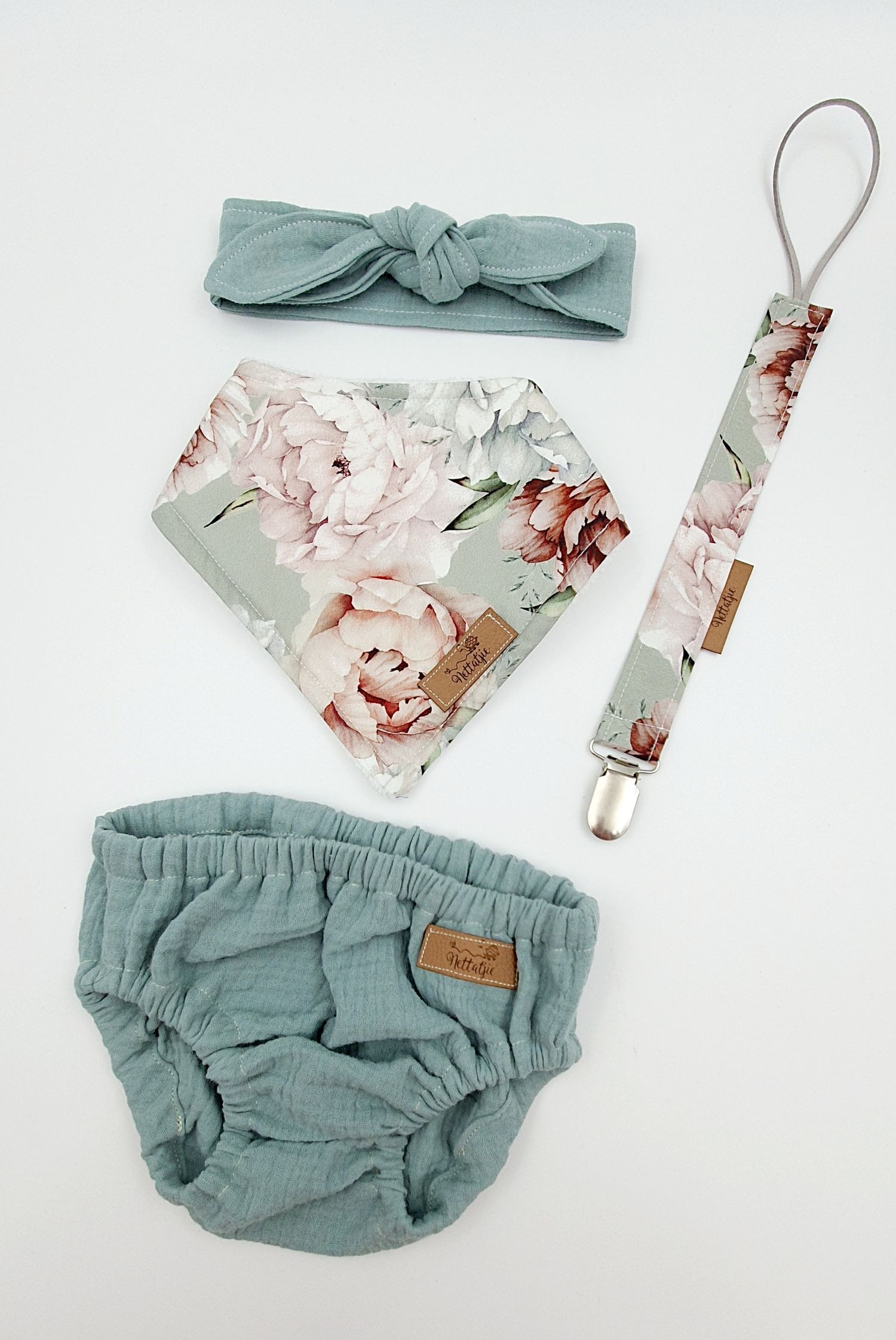 Sage green baby girl set with floral bandana bib, muslin bloomer, knotted headband, and matching pacifier clip.