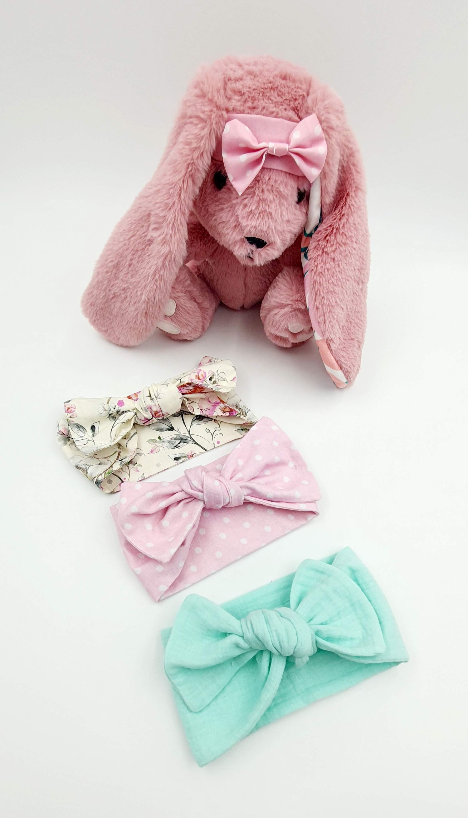 Pink plush bunny with coordinating floral and mint green hair bows displayed on white background.